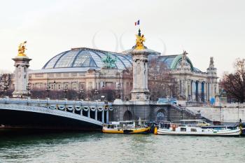 Pont Alexandre III and Grand Palais in the background, in Paris evening