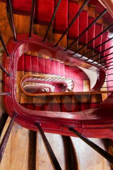 spiral steps with red carpet strip in old house