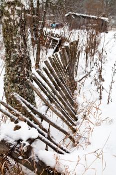 ramshackle wooden palisade in winter village