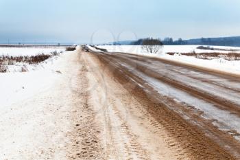 slippery country road in winter afternoon
