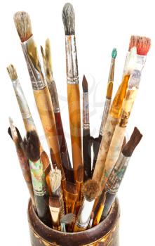 many used artistic paintbrushes in wooden cup isolated on white background