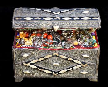 ancient east treasure chest with antique jewelry isolated on black background