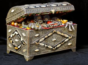 ancient east treasure chest with antique jewelry on black textile