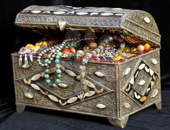 ancient east treasure chest with antique jewelry on black clothes