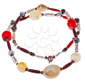 necklace from beads of large agate stones, red coral, carved horn and bone isolated on white background