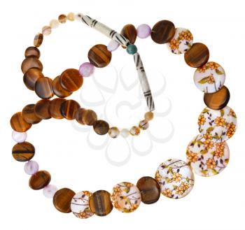 necklace from natural mineral beads of decorated nacre, tigers eye stones, carved bone isolated on white background
