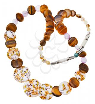 top view of necklace from natural mineral beads of decorated nacre, tigers eye stones, carved bone isolated on white background