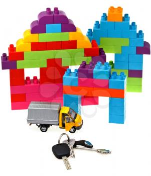 plastic block house, door and car keys, model truck on white background