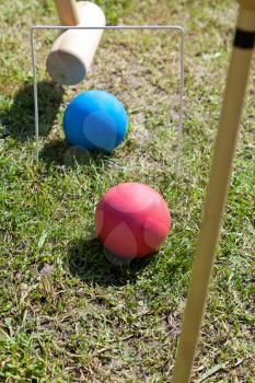 blue and red balls in game of croquet on green lawn