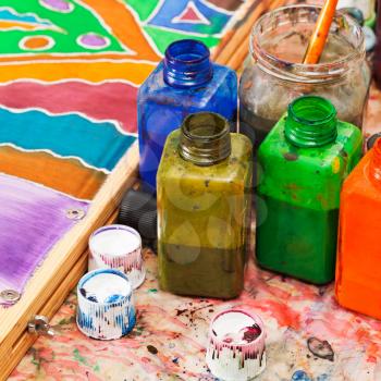 paintbrush and bottles with dyes for cold batik