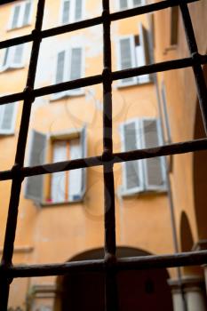 view through window iron bars on italian urban house court