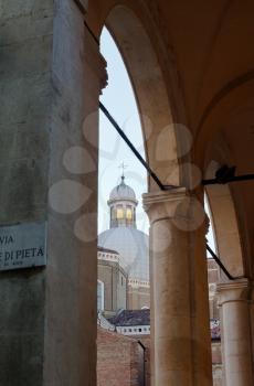 view of Padua Cathedral dome through arcade on via di Pieta in Padua, Italy