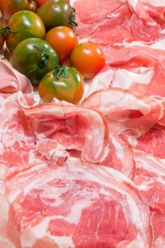 food background from italian prosciutto, pancetta and green tomato