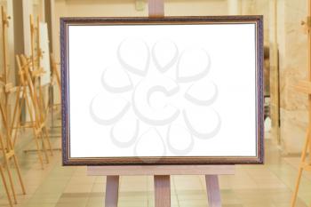 big picture frame with white cut out canvas on easel in art gallery