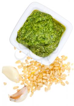 top view on italian pesto with pine nuts and garlic cloves isolated on white background