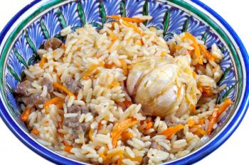 traditional asian pilaf with garlic bulb in ceramic bowl close up
