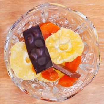 dried fruits and chocolate bar in glass bowl