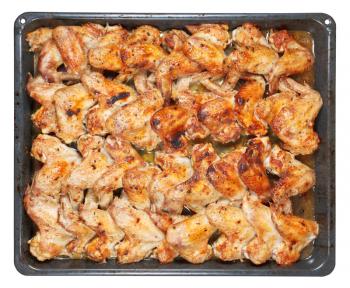 many roasted spicy chicken wings on hot tray isolated on white background
