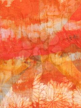 abstract ornament of painted orange silk batik close up