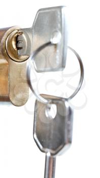 bunch of home keys in cylinder lock close up isolated on white background