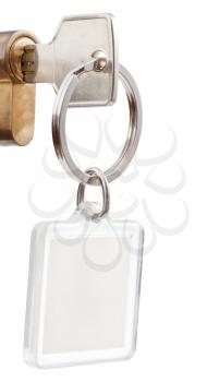 home key with square keychain in cylinder lock close up isolated on white background