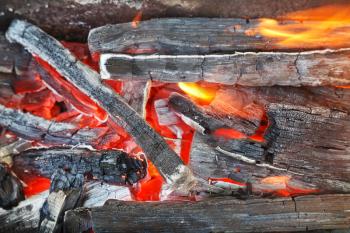 flame over burning wood-burning coals close up