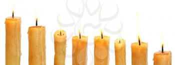 set of lighted candles close up isolated on white background