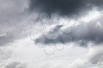 dark grey rainy clouds in overcast sky in summer
