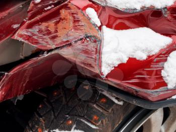 strongly crumpled fender of red car after winter traffic accident