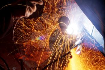 sparks during welding car turnbuckle in field at night