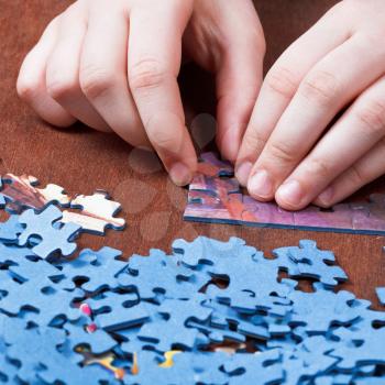 playing with jigsaw puzzles on wooden table