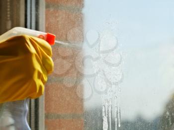 cleaning window glass - soapy solution jet from spray bottle