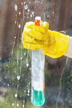 soapy liquid on window glass during washing from spray bottle