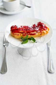 pastry eclair on white plate on table