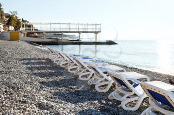 chairs on urban Massandrovskiy pebble beach in Yalta, Crimea