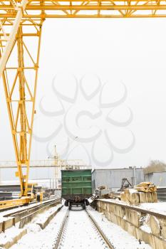 gantry crane over railway carriage in outdoor warehouse area