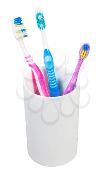 one children and two adult toothbrushes in ceramic glass - family set of toothbrushes isolated on white background