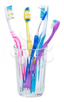 four toothbrushes and interdental brush in glass - family set of toothbrushes isolated on white background