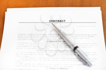 silver pen on sheet of sales contract on wooden table