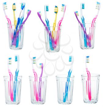 collection of tooth brushes in clear glases isolated on white background