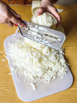 woman chopping cabbage on cutting board on table