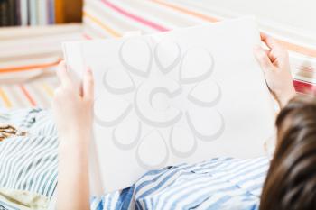 girl read book with blank pages in living room