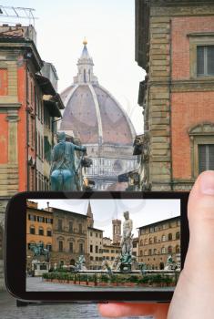 travel concept - tourist taking photo of Piazza della Signoria in Florence on mobile gadget, Italy
