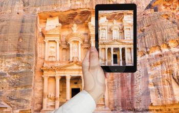 travel concept - tourist taking photo of Treasury Monument and plaza in ancient city Petra on mobile gadget, Jordan