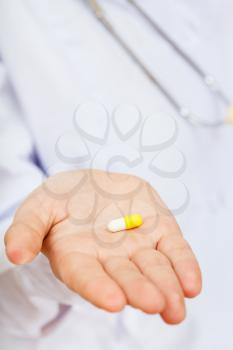 nurse holds pill on palm close up