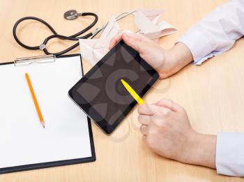 doctor works with tablet pc during appointment