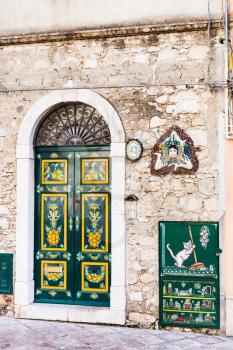 TAORMINA, ITALY - APRIL 3, 2015: typical decoration of urban house door and Trinacria - symbol of Sicily.
