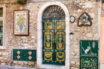 TAORMINA, ITALY - APRIL 3, 2015: traditional decoration of urban house facade and Trinacria - symbol of Sicily.