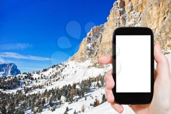 travel concept - tourist photograph slope of Dolomites mountain in Val Gardena, Italy on tablet pc with cut out screen with blank place for advertising logo