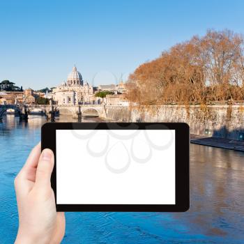 travel concept - tourist photograph autumn view on Tiber river and St Peter Basilica in Rome, Italy on tablet pc with cut out screen with blank place for advertising logo